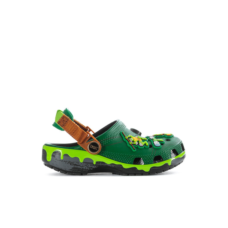 Kids green clog with TMNT graphic, orange-brown strap and black tread sole