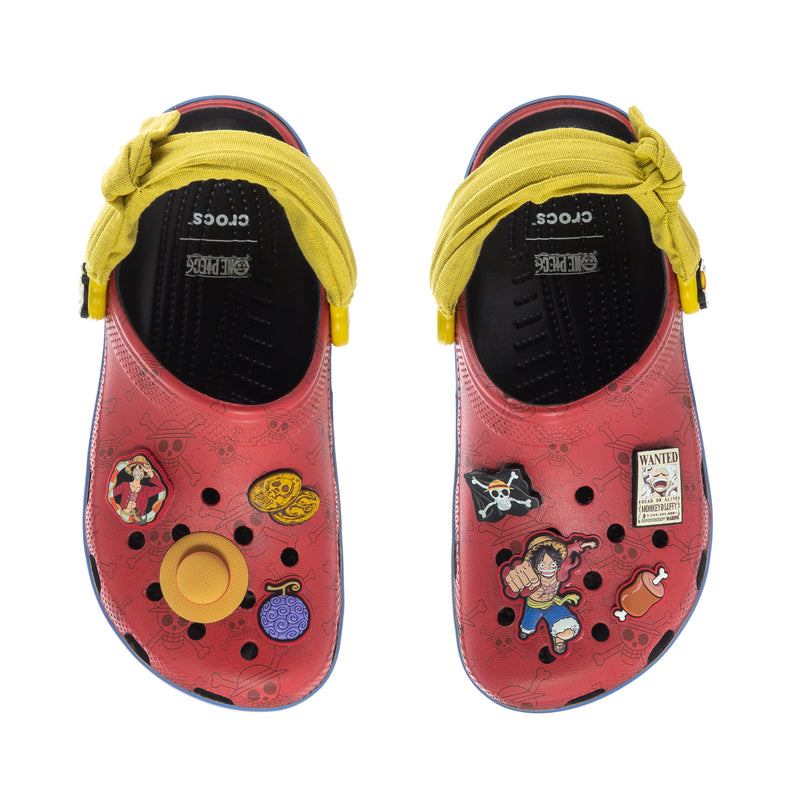 Two youth clogs viewed from top: pink/red uppers with yellow straps and Crocs branding on insole