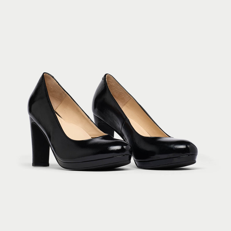 Pair of black high-heeled shoes on a light gray background
