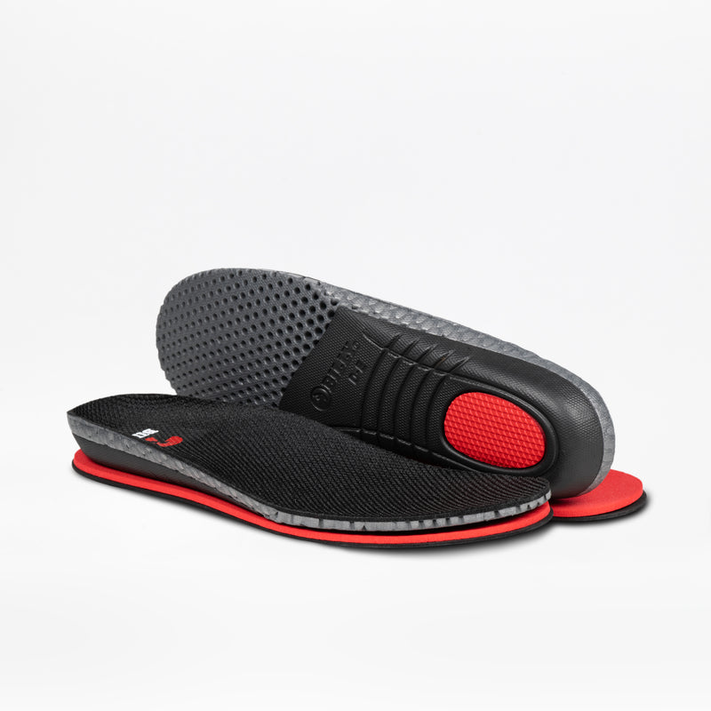 A pair of black and red insoles, with one flat and one propped to reveal the gray textured bottom and red heel cushion, designed for enhanced comfort in BILLY Footwear's Men's White Leather BILLY Comfort Luxe shoes.