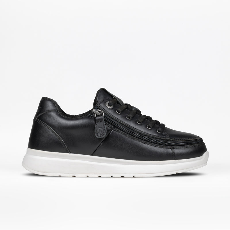 The Women's Black Leather BILLY Comfort Plush sneaker by BILLY Footwear features black laces, a wraparound zipper, and a thick white sole, displayed in profile on a plain white background.